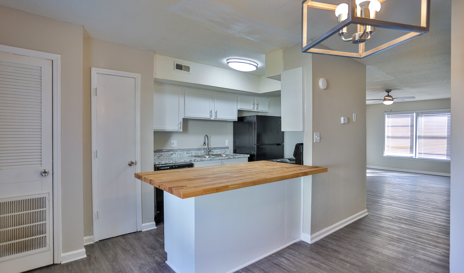 spacious and well lit kitchen with butcher block counters and sleek black appliances 